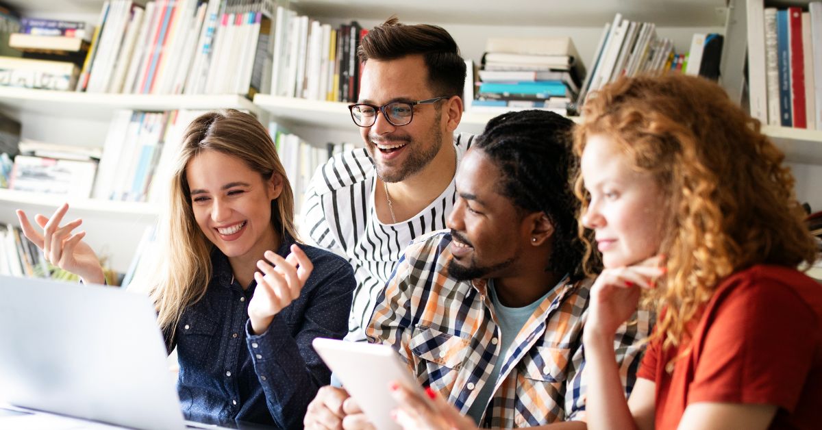 Team working together on a laptop smiling