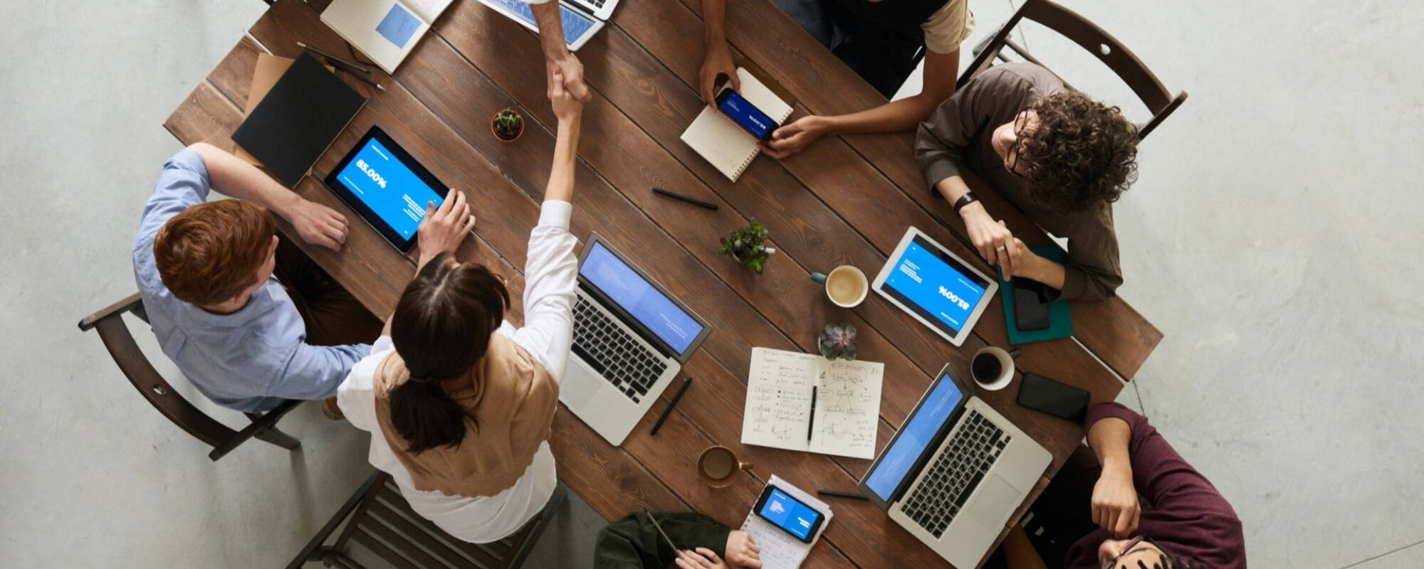 People shaking hands across a meeting table