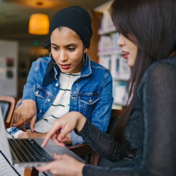 Two people working on one computer